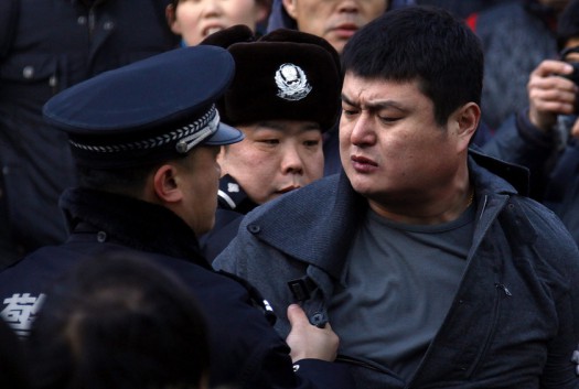 A man is dragged away by the police after he refused to leave the front of the Apple store in Beijing